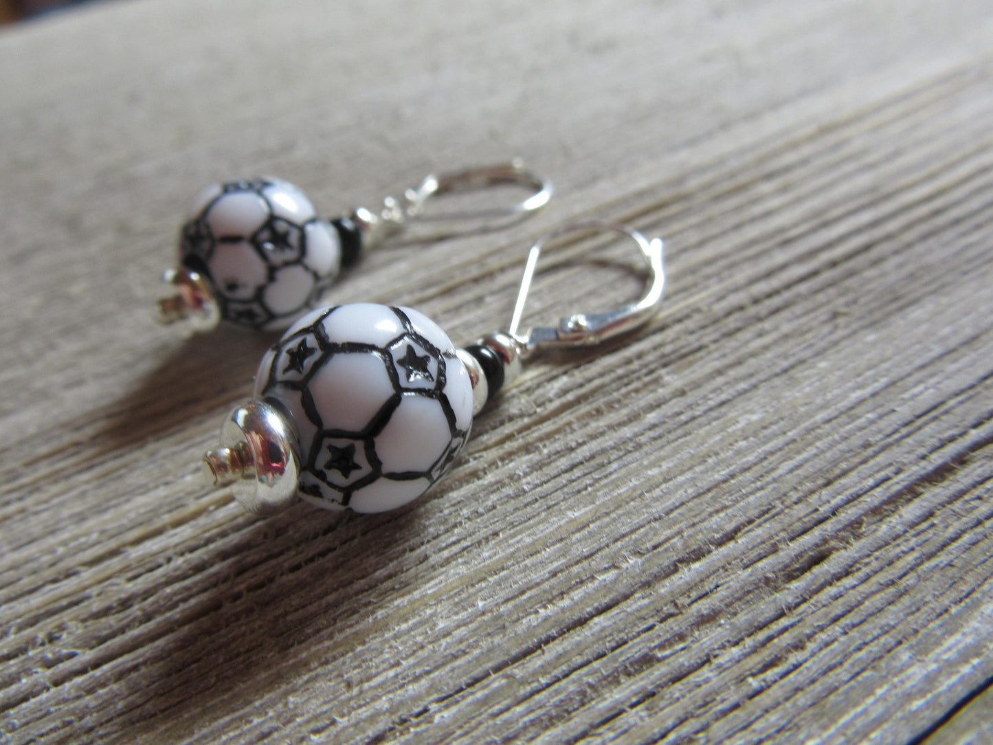 Flat lay of Soccer Ball Earrings showcasing their dangle design - Sports Theme Jewelry - Novelty Women Accessories by Enlivenadorn by Gwynstone.
