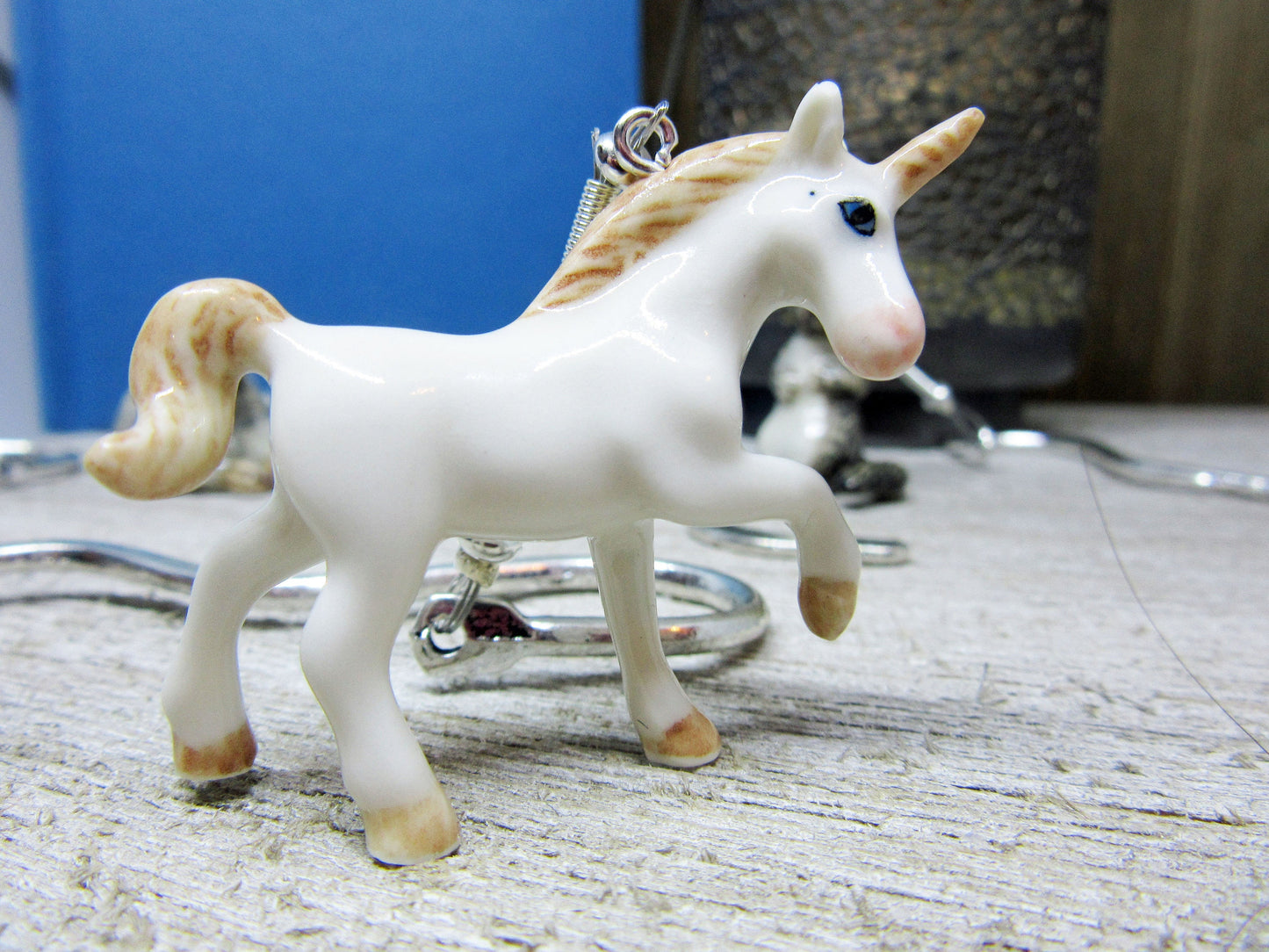 Platypus Figurine Bookmark displayed beside an open book, highlighting the unique design of the porcelain duck-billed platypus, a great gift for those who love water life.