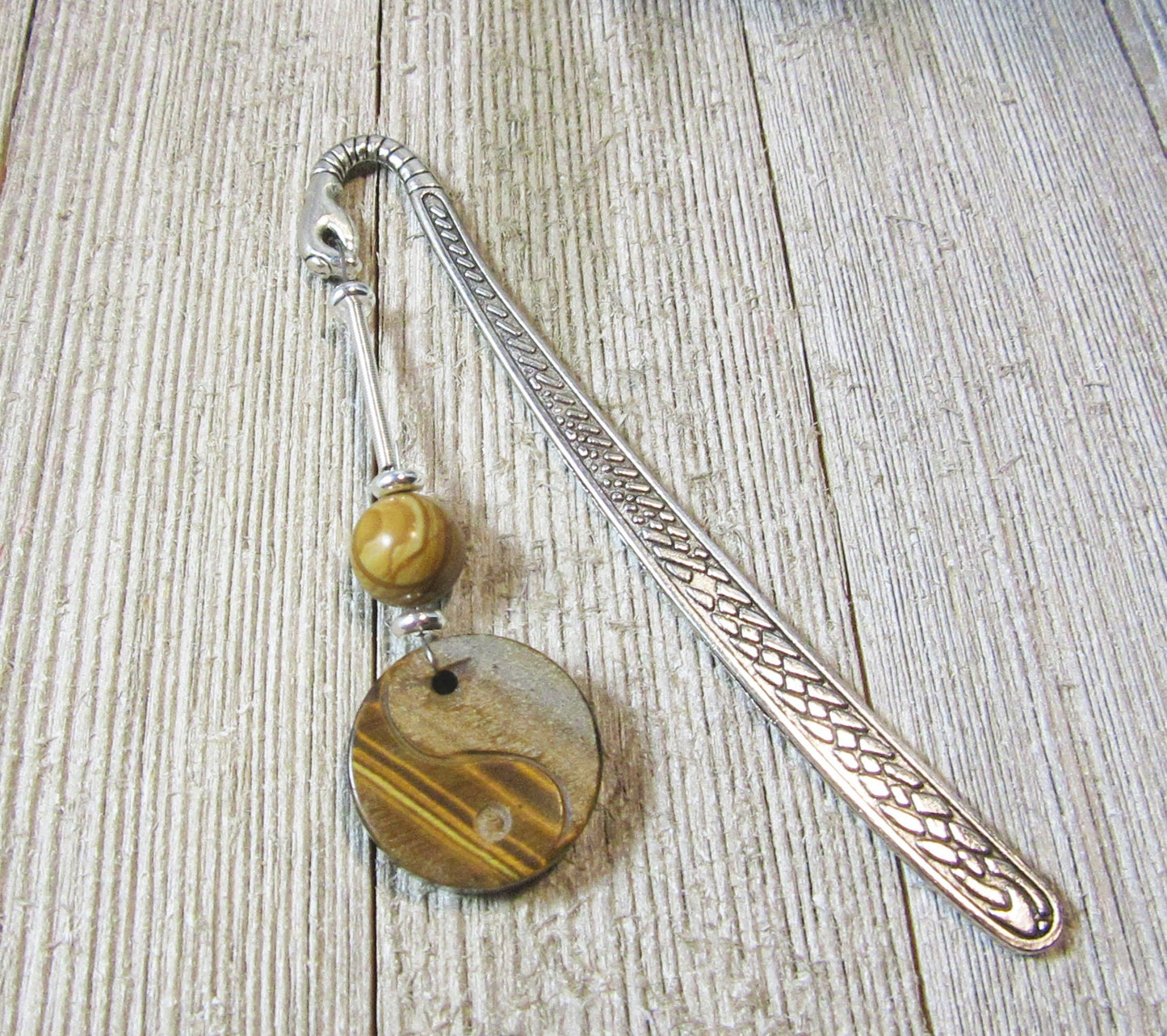 Yin Yang Bookmark displayed on a book, showcasing its unique design, ideal for readers and spiritual individuals.