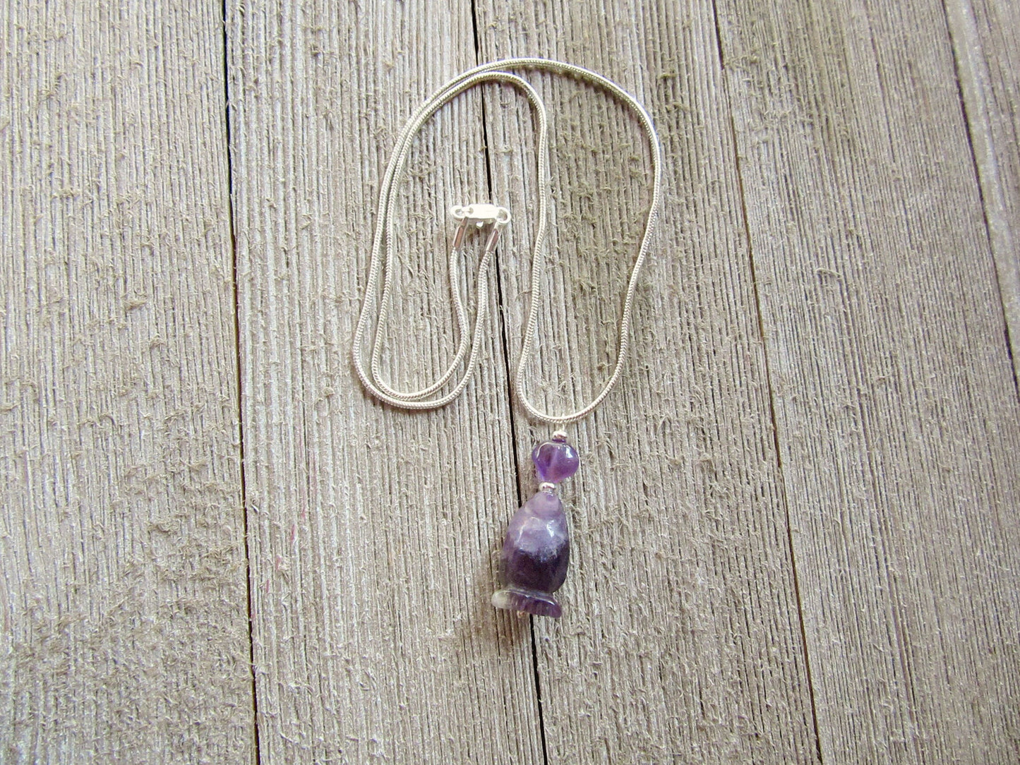 Handmade penguin necklace crafted from amethyst gemstones, a unique gift for her featuring a cute carved stone animal.