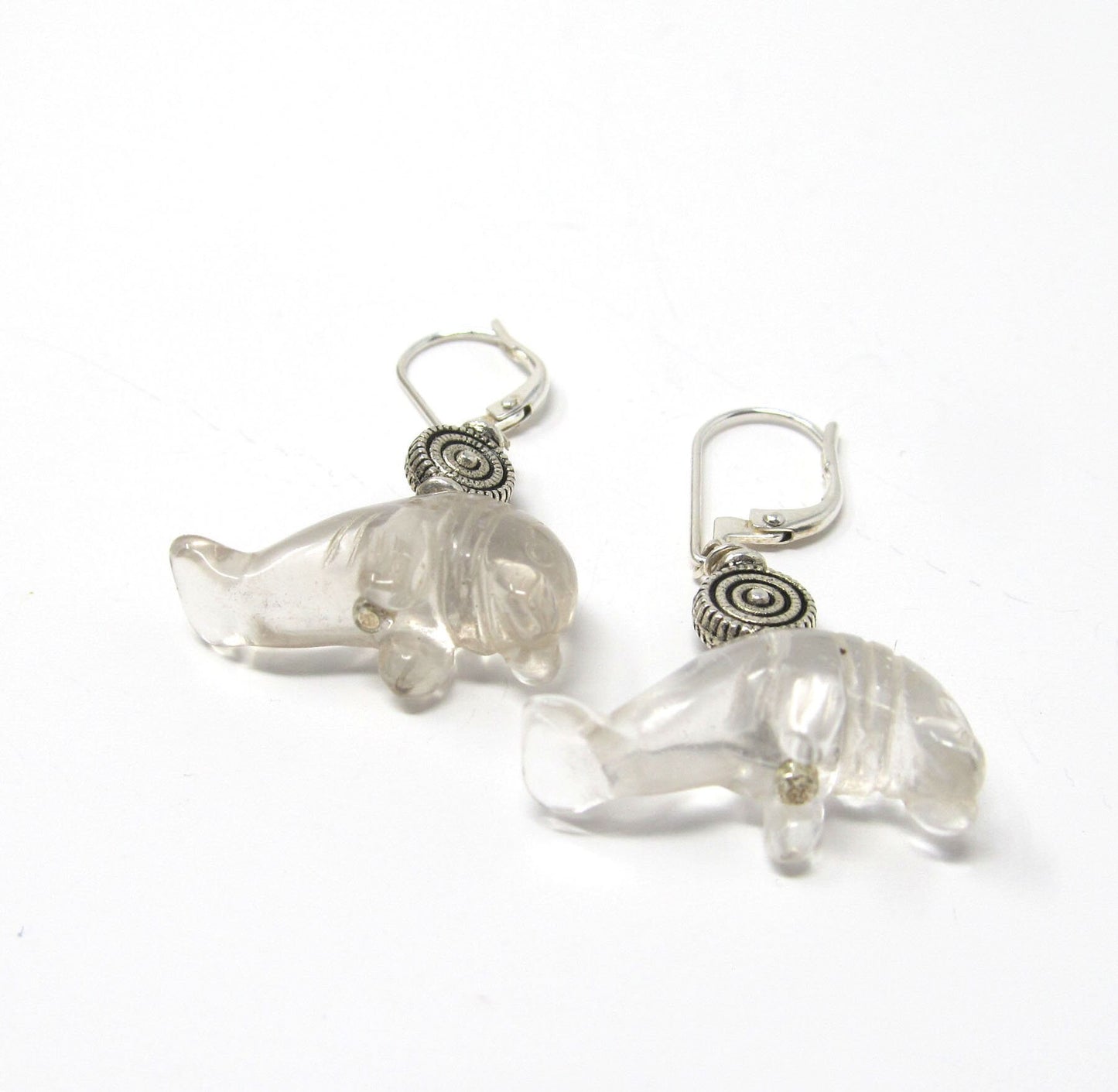 Close-up of carved stone Manatee Earrings with clear quartz drops, ideal for Florida wildlife lovers and ocean enthusiasts.