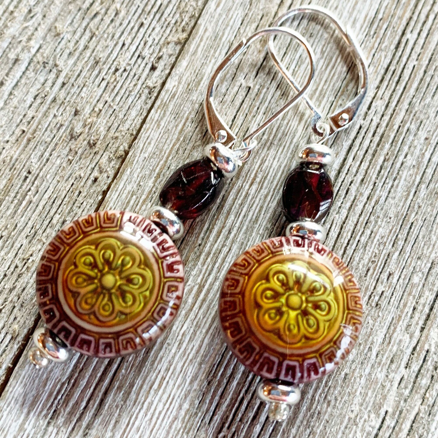 The Garnet Mandala Earrings and Necklace Set features artisan-designed, zen-style mood beads in a boho jewelry look—ideal for those who appreciate meditation-inspired accessories, beautifully displayed on a wooden surface.