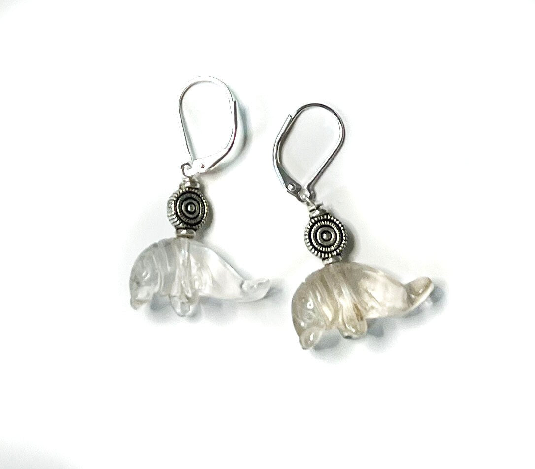 Close-up of Clear Quartz Drop Earrings shaped like manatees, showcasing detailed carvings ideal for ocean-themed gifts.