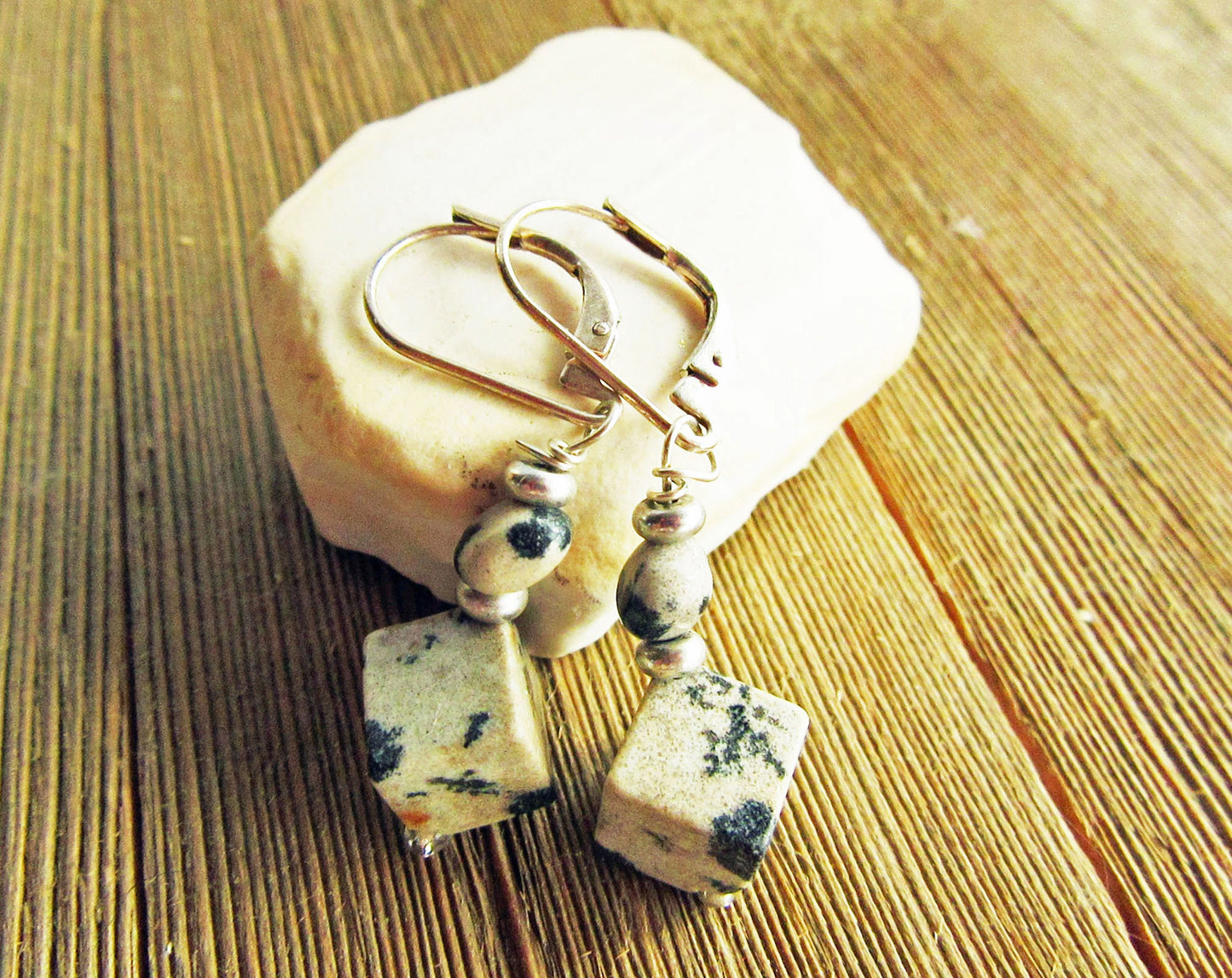 Elegant display of Sacred Geometry Dalmatian Jasper Cube Earrings in sterling silver, emphasizing the healing properties of Dalmatian Jasper.