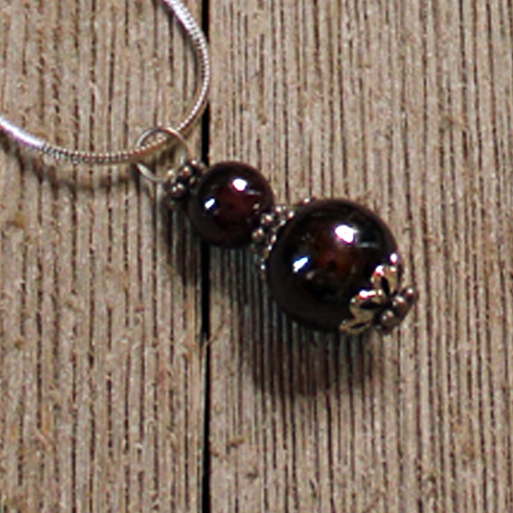 Elegant display of Sacred Geometry Garnet Earrings, showcasing unique geometric shapes and artisan handmade quality in sterling silver.