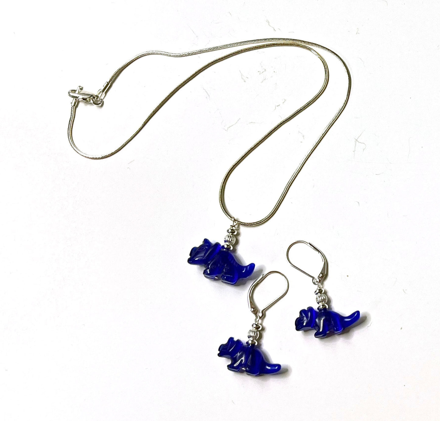 Close-up of Triceratops earrings - blue dinosaur jewelry with intricate details, ideal silly gift for a geeky friend.
