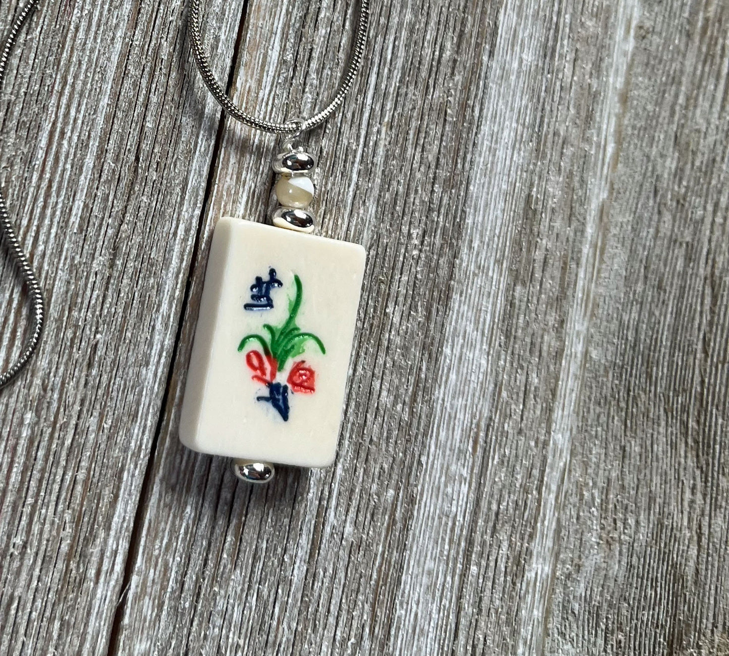Elegant Mahjong Tile Necklace with flower motif, a unique jewelry piece for Mahjong enthusiasts.