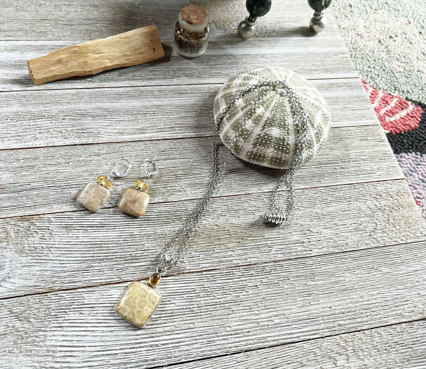 Fossil Coral Jewelry Set with Topaz Topper featuring a 24-inch necklace with strong magnetic clasp and 2-inch fossilized coral pendant, along with matching lever back sterling silver earrings.