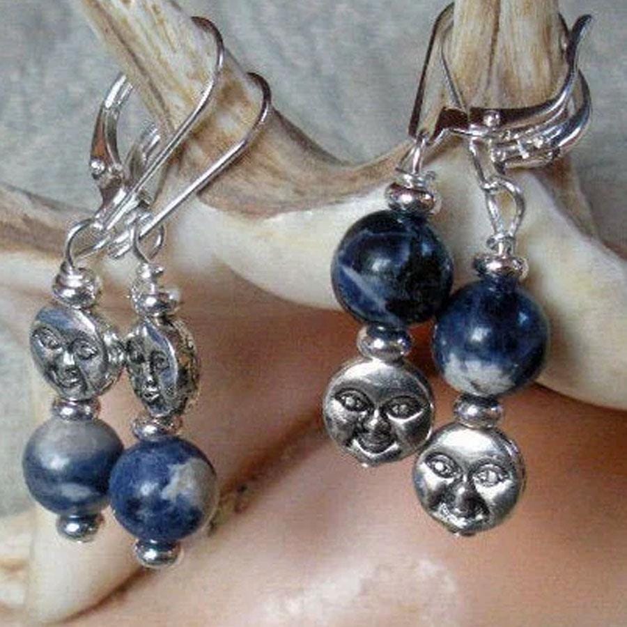 Celestial Sodalite Earrings: Handmade Sterling Silver Moon Jewelry featuring round blue sodalite beads and sun face charms, elegantly displayed on a seashell—ideal witchy earrings for any celestial jewelry lover.