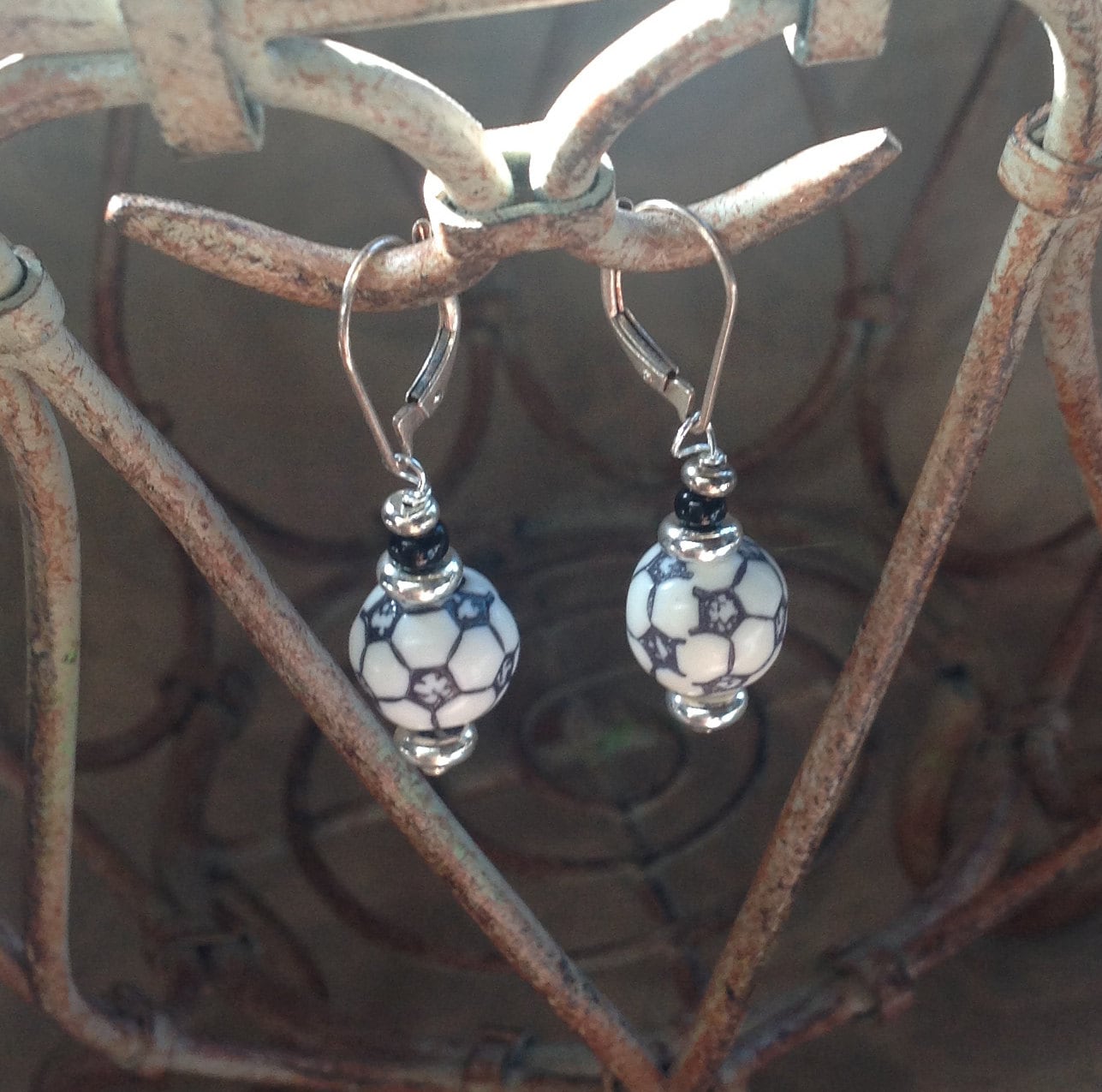 Model wearing Soccer Ball Earrings while watching a soccer game - Soccer Sport Earring - Sport Ball Earrings by Enlivenadorn by Gwynstone.