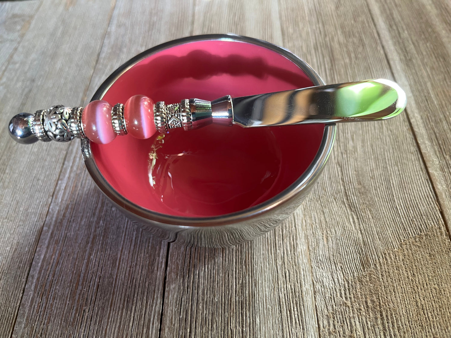 Fabulous Facets Collection Artisan Deep-Bowled Serving Scoop alongside a vibrant pink bowl, featuring an ergonomic silver handle adorned with decorative beads, perfect for enhancing kitchen aesthetics.