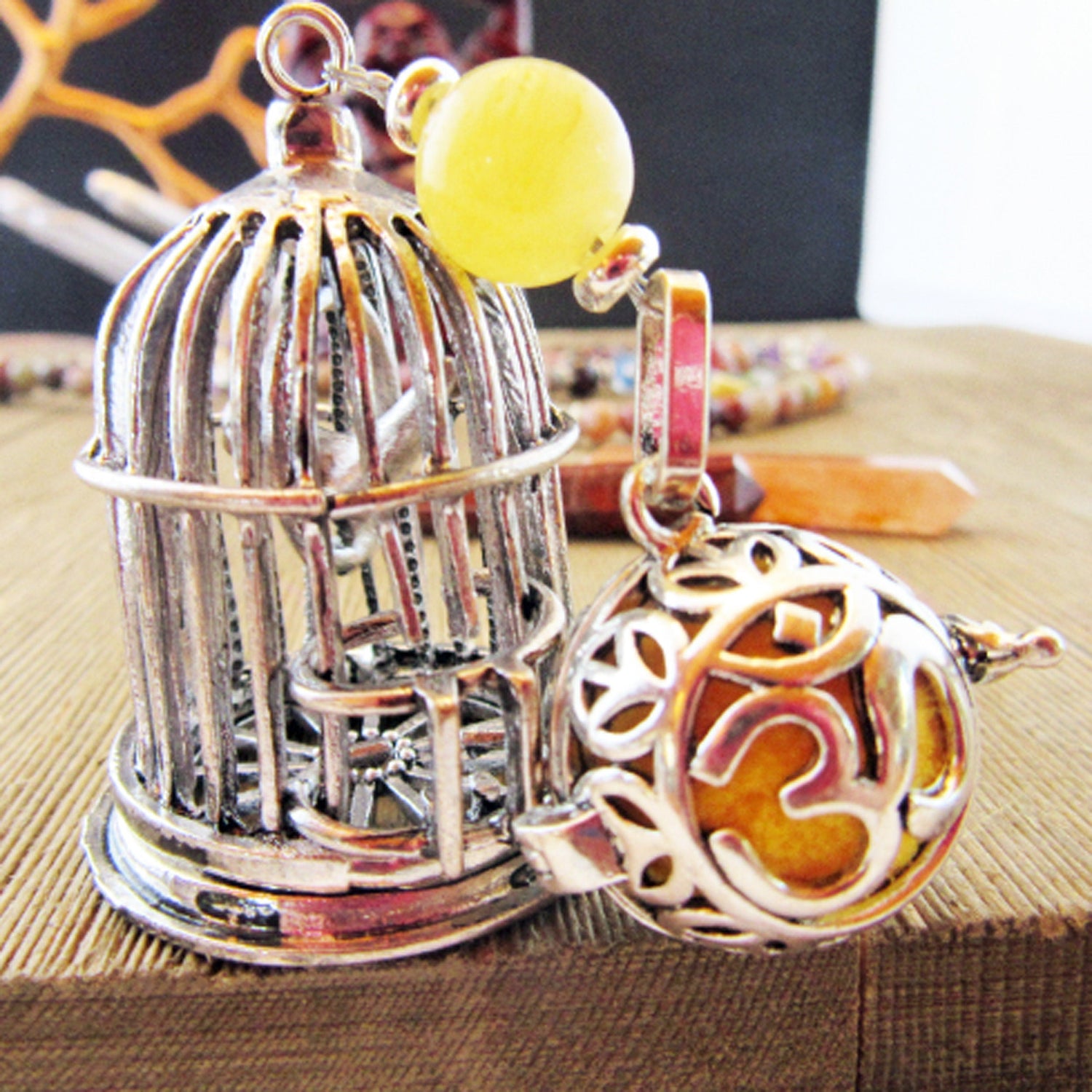 Intricate metal birdcage pendant with a yellow bead, beautifully showcasing charm and creativity in our vibrant home collection. Perfect for adding a unique touch to your lifestyle accessories.