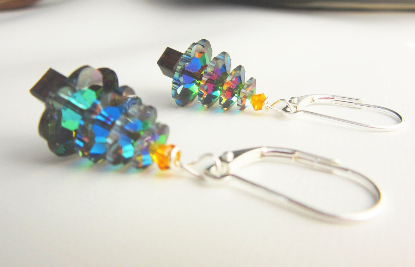 The Crystal Christmas Tree Earrings – Sterling Silver Holiday Dangle feature stacked iridescent crystals, a small yellow bead at the base, and silver hooks—perfect festive earrings for the holidays.