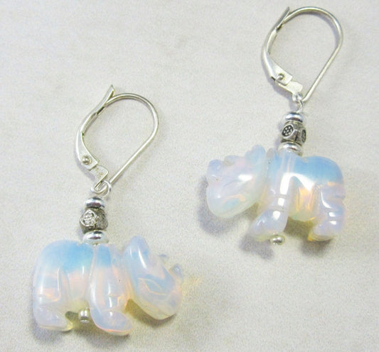 The Opalite White Rhino Earrings – Safari Wildlife Jewelry feature iridescent opalite rhinoceros charms and are displayed on a light gray background, said to inspire emotional balance.