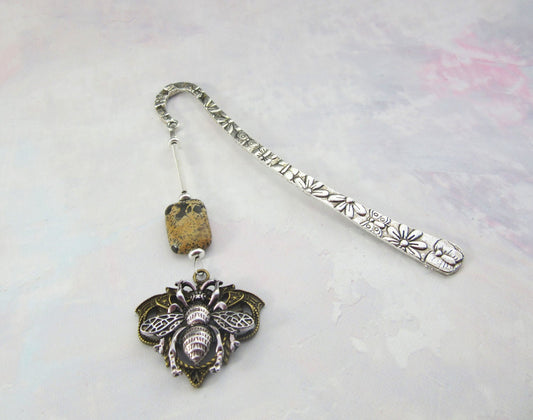 The Handmade Honeybee Bookmark: Bronze & Silver Floral Metal features floral engravings, a speckled bead, and an ornate silver-toned bee pendant—an ideal mindfulness gift for book lovers.
