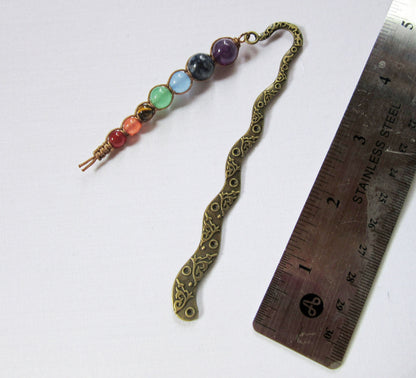 Handcrafted chakra metal bookmark with 7 beads symbolizing root, sacral, solar plexus, heart, throat, third eye, and crown chakras, ideal for book lovers.