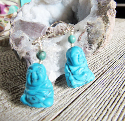 Close-up of the Smiling Happy Man Zen Earrings, showcasing carved figure stone and turquoise healing elements.
