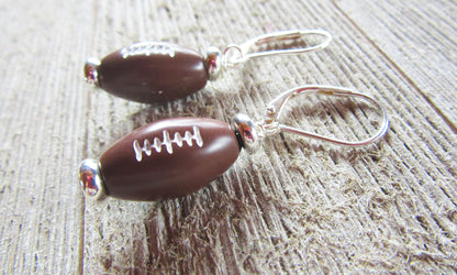 Close-up of Football Novelty Earrings, perfect sports-themed gift for football fans, featuring secure lever back ear wires.