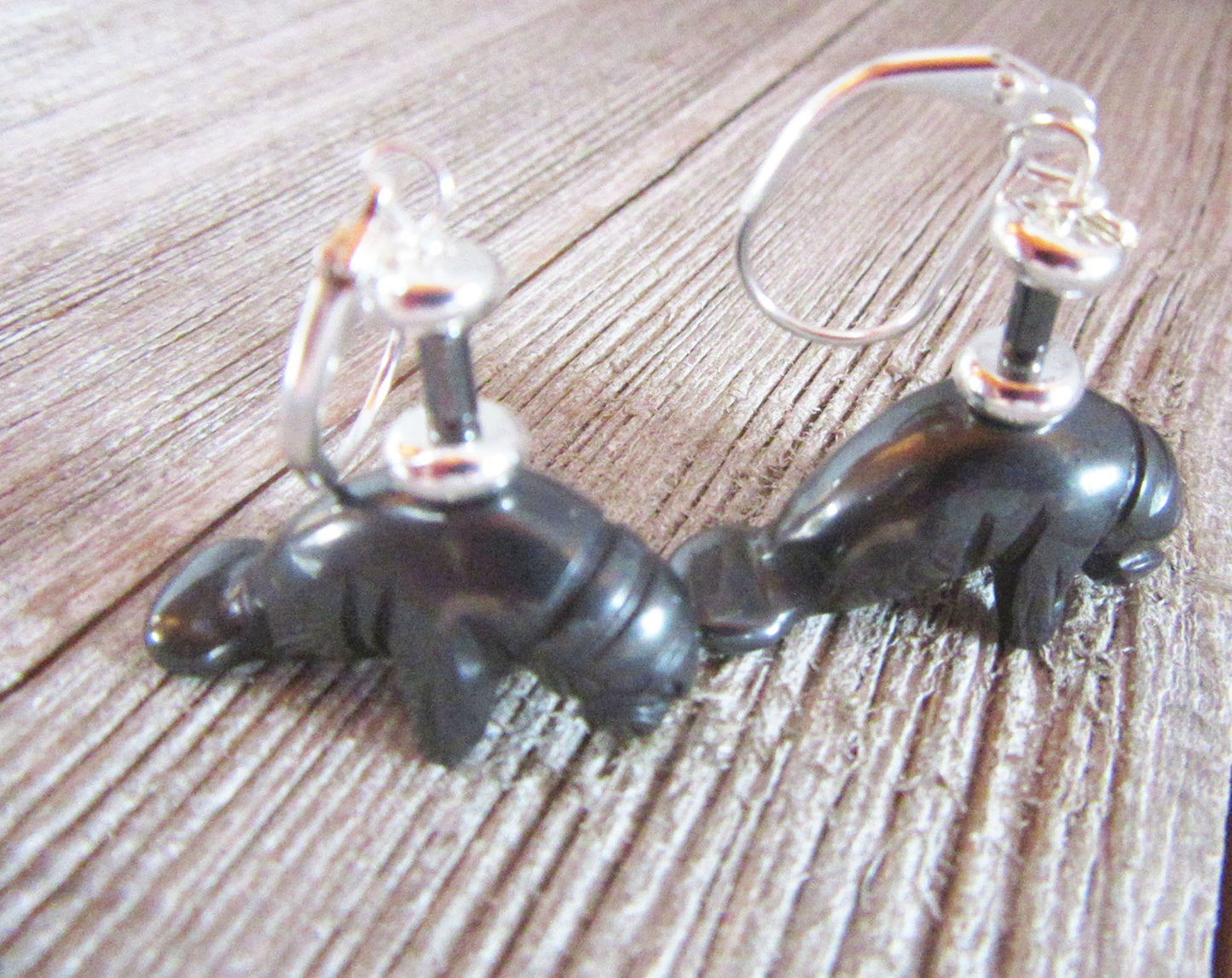 Hematite Manatee Earrings: Sea Life Dangle Jewelry—black manatee-shaped earrings with silver hooks, ideal for sea life jewelry lovers seeking unique dangle accessories.