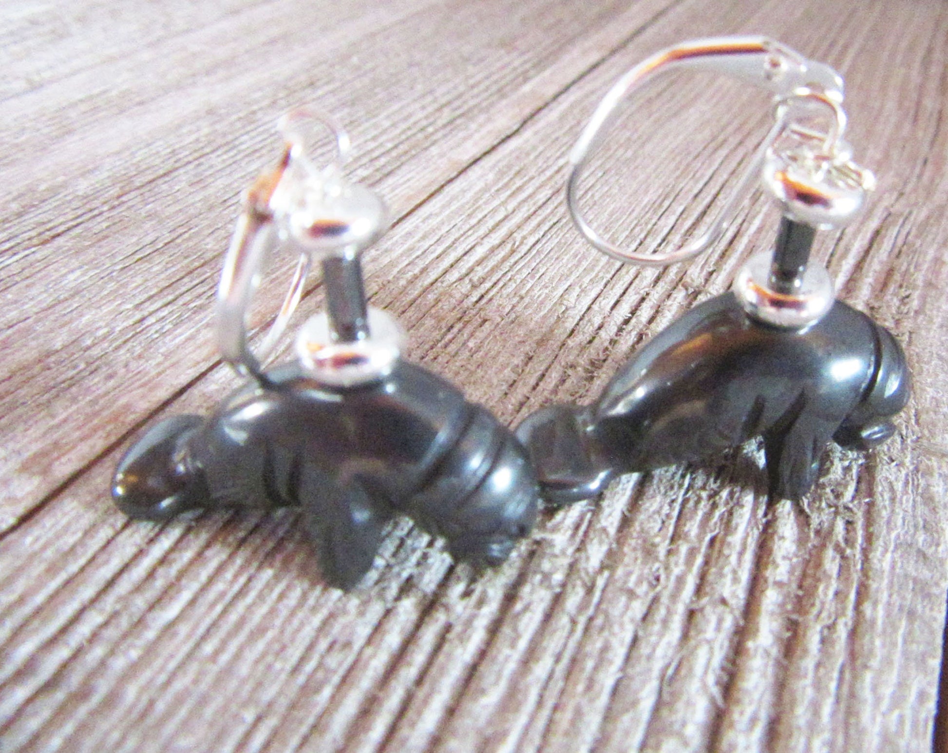 Hematite Manatee Earrings: Sea Life Dangle Jewelry—black manatee-shaped earrings with silver hooks, ideal for sea life jewelry lovers seeking unique dangle accessories.