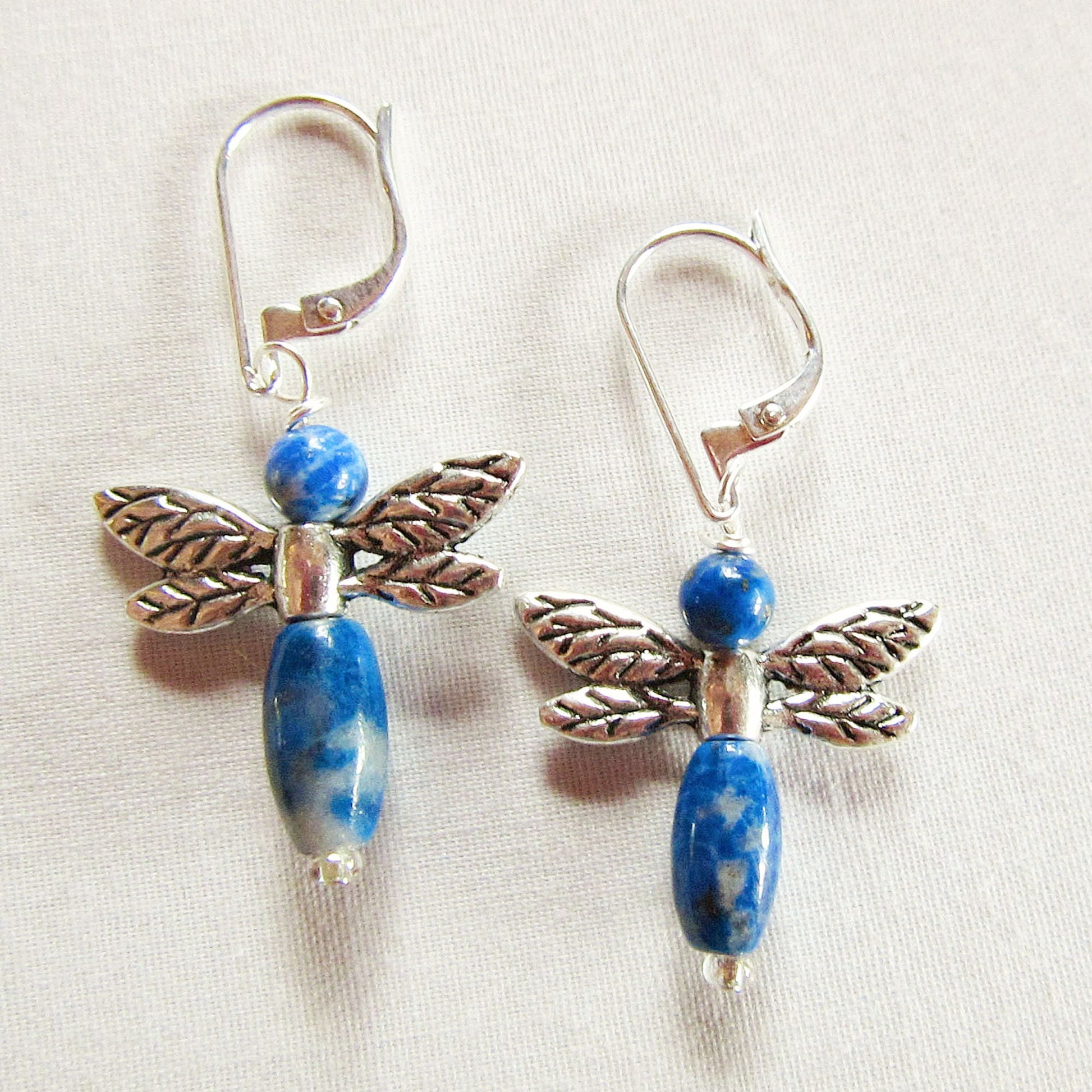 Blue Sodalite Dragonfly Earrings with stone beads, sterling silver lever backs, and leaf-shaped details—Gift of Eternity—displayed on a light fabric background.
