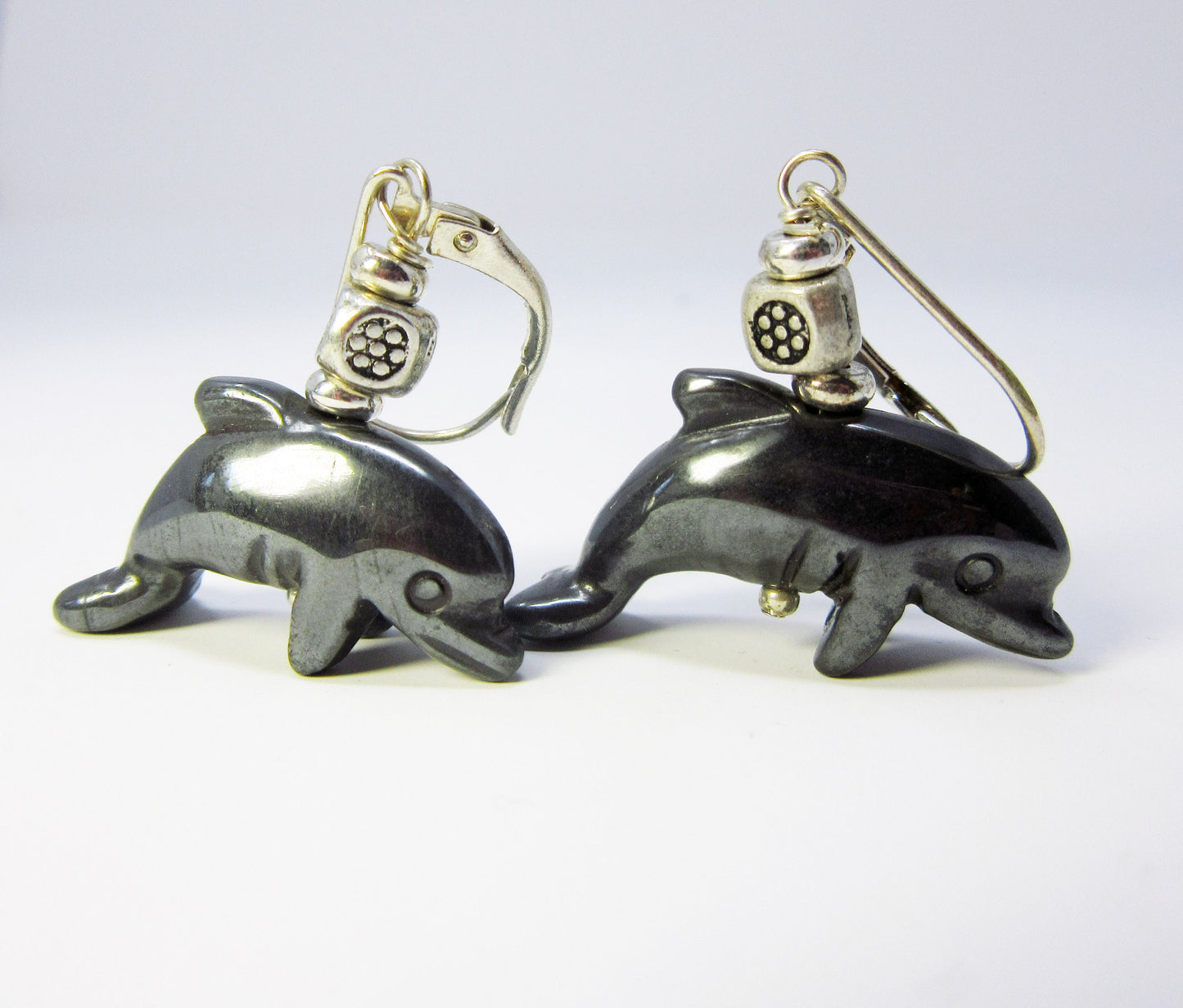 Handcrafted Hematite Dolphin Earrings – Animal Lover Jewelry featuring black dolphin-shaped pendants and silver scuba diver helmet charms, designed for grounding energy, displayed on a plain white background.