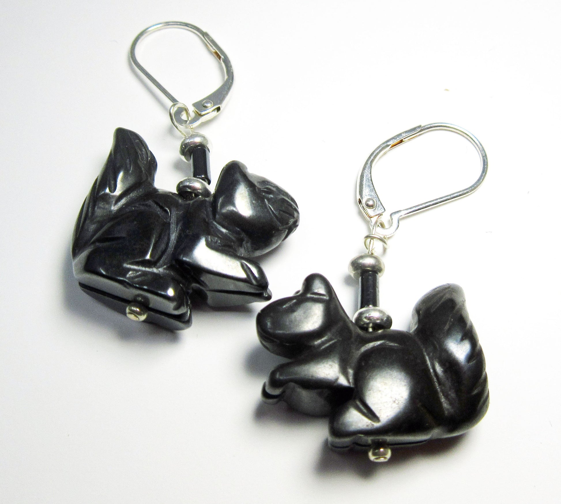 Squirrel Earrings: Carved stone squirrel charms with black beads hang from sterling silver lever backs, shown on a white background.