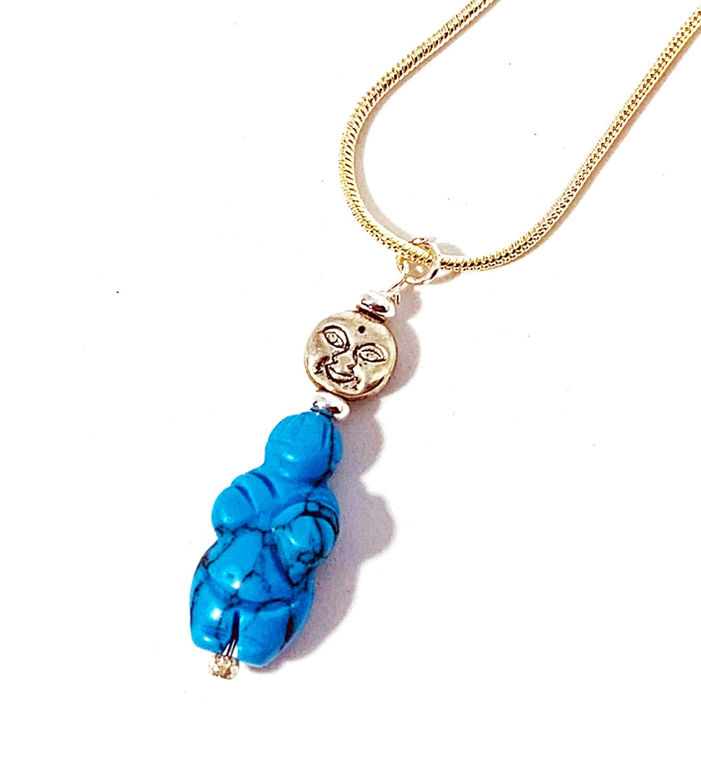 The Turquoise Goddess Pendant: Sterling Silver Fertility Necklace showcases a silver moon face charm above a blue carved pendant, displayed on a white background.