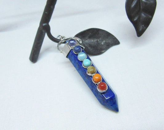 The Chakra Stones Pendant features seven colorful gemstones in a vertical design on a silver chain. This healing gemstone jewelry is ideal for yoga lovers and adds vibrant energy to your style.