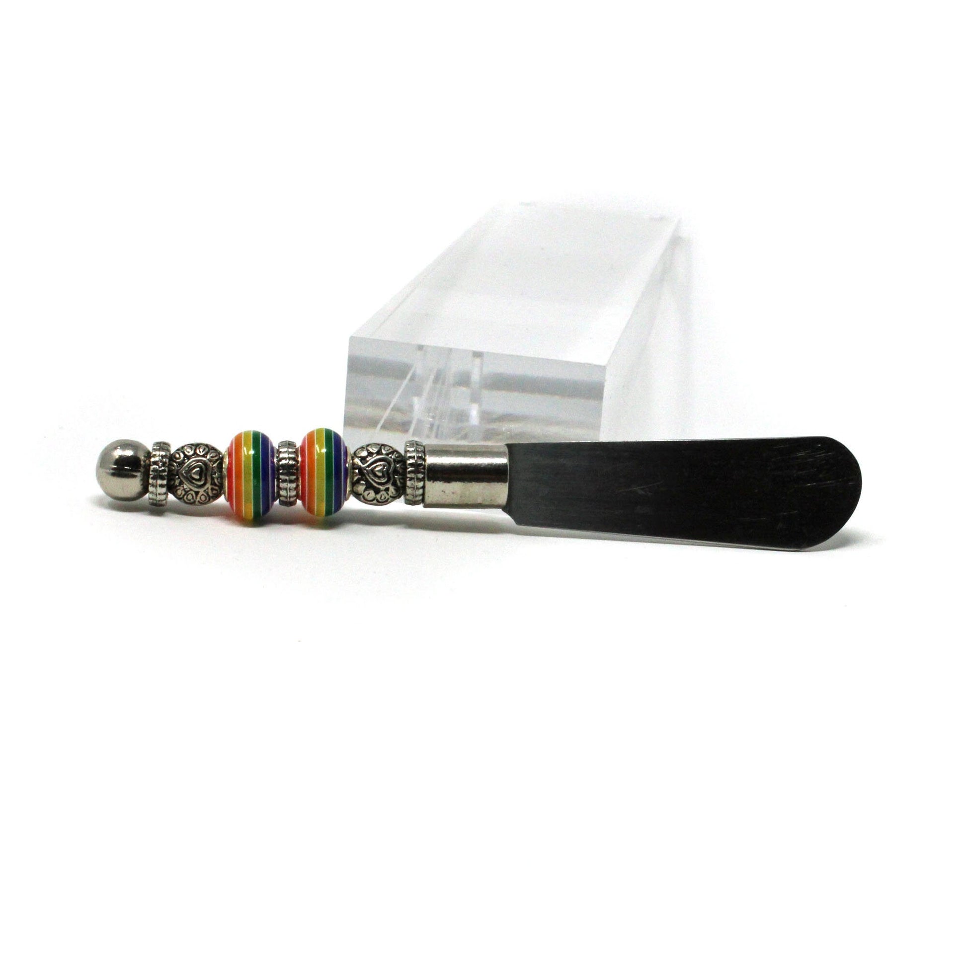 The Rainbow Pride Cheese Spreader Knife features a colorful, handcrafted handle—perfect as a fun kitchen accessory or unique gift for housewarmings and hosts, and ideal for charcuterie boards at any gathering.