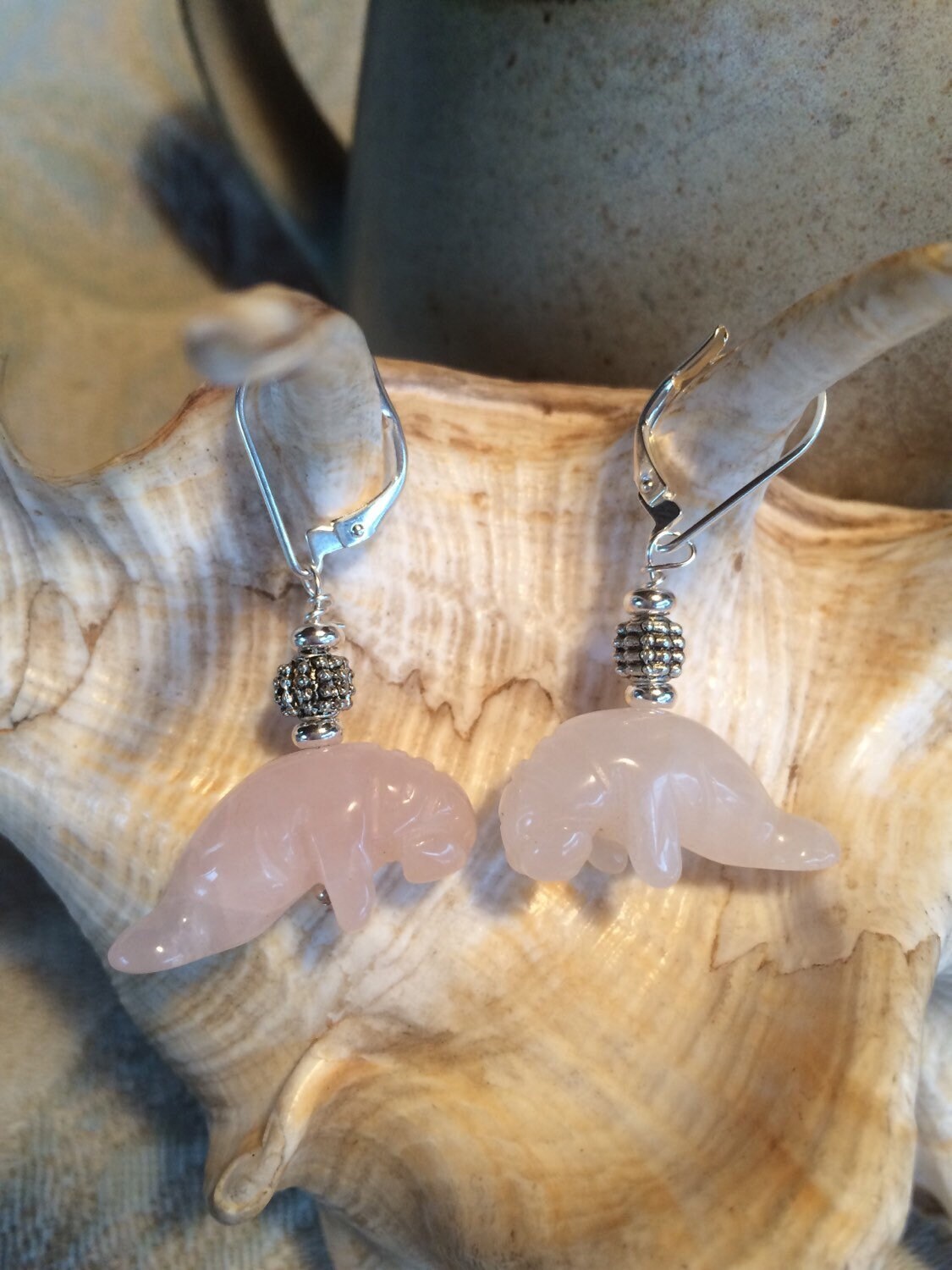 Rose Quartz Manatee Earrings - Handcrafted Gemstone Ocean Jewelry: Features carved pink stone manatee charms and silver beads, displayed on a light seashell—ideal for fans of unique gemstone accessories.