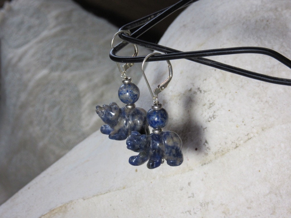 Whimsical Handcrafted Sodalite Bear Earrings feature small blue gemstone bear charms and round blue beads, hanging from sterling silver lever backs, shown on a black cord against a light background.