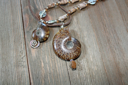 Ammonite fossil partner jewelry necklace set featuring an inch and a half pendant with opalescent bands.