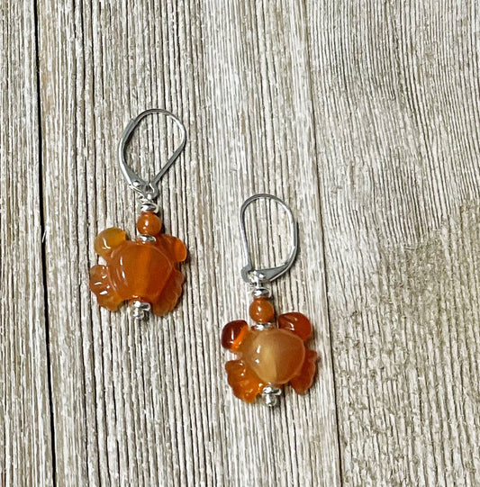 Crab Earrings: Carved carnelian artisan-designed dangle jewelry with animal motifs and silver hooks, shown on weathered wood—perfect for fans of unique gemstone accessories.