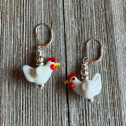 Close-up of the Hen Earrings Gift that is egg strodinary - highlighting unique white lamp work glass chicken design, ideal for chicken lovers and farm enthusiasts.