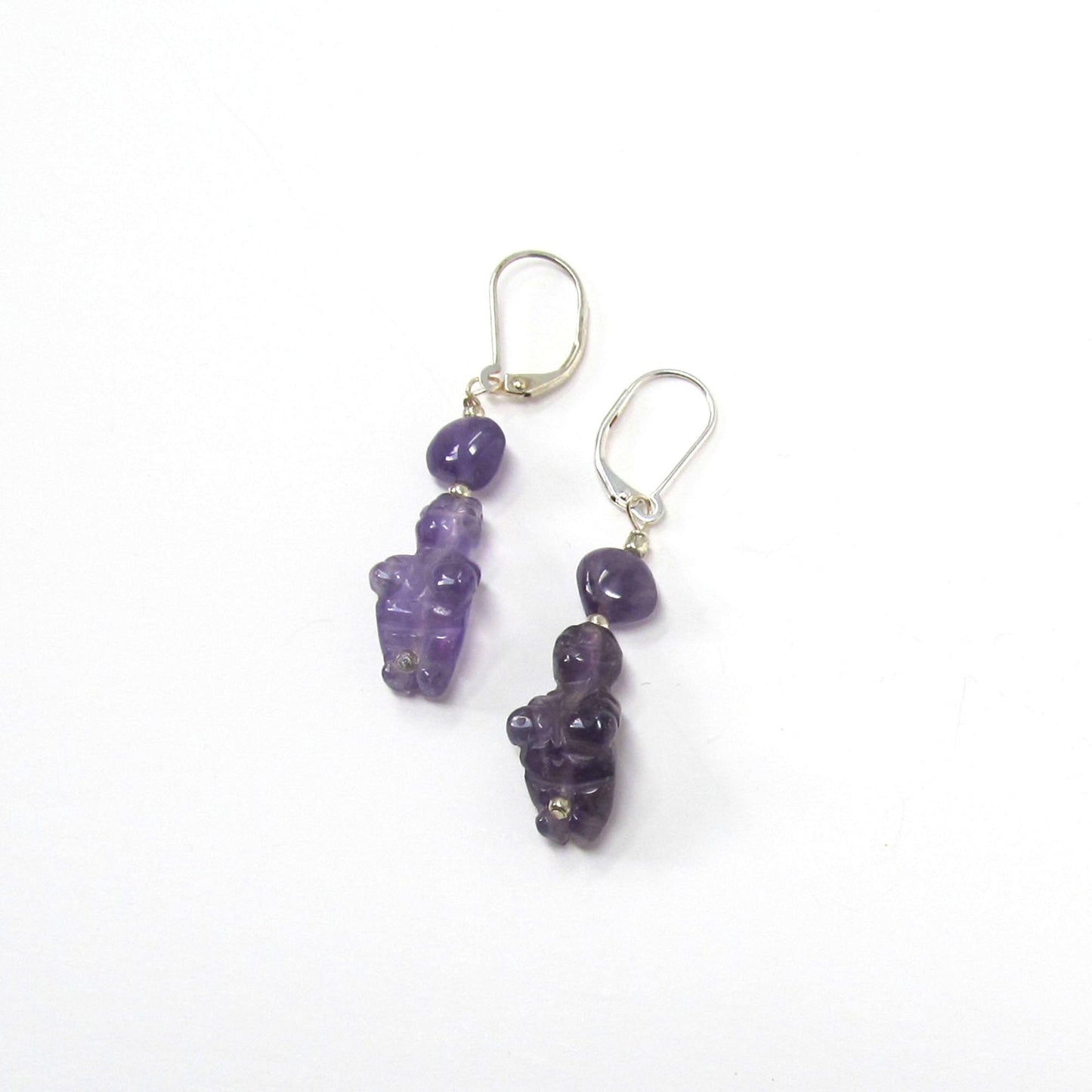 The Handcrafted Amethyst Goddess Earrings: Willendorf Venus Jewelry feature silver hooks with dangling purple gemstone beads, each uniquely shaped, adding artisanal charm and elegance to any outfit.