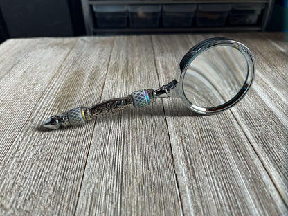 Close-up of Eye Catching Gift - Shimmering Bead Handed Magnifier showcasing its 2-inch lens and artistic design, ideal office crafting tool.