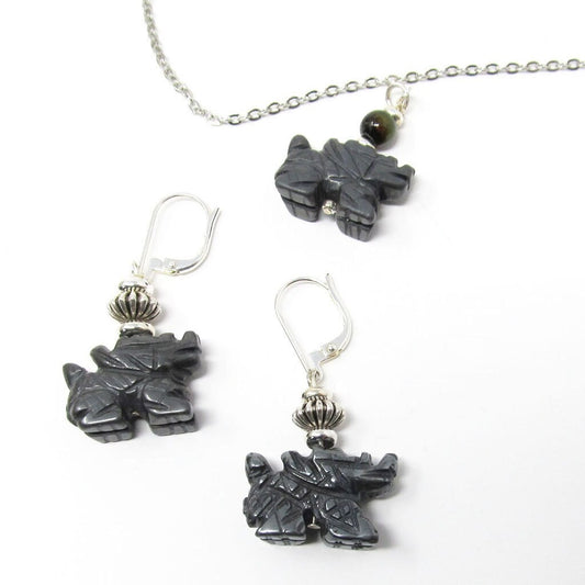 The Handcrafted Hematite Dragon Jewelry Set includes sterling silver earrings, a necklace, and a bangle. Each piece features dark hematite accents and is beautifully displayed on a white background.