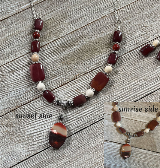 Mookaite Jasper Necklace & Sterling Silver Earrings Set: Handcrafted nature jewelry with a gemstone pendant shown on wood. Inset images reveal unique sunrise and sunset sides of the pendant, featuring distinct reddish and cream patterns.