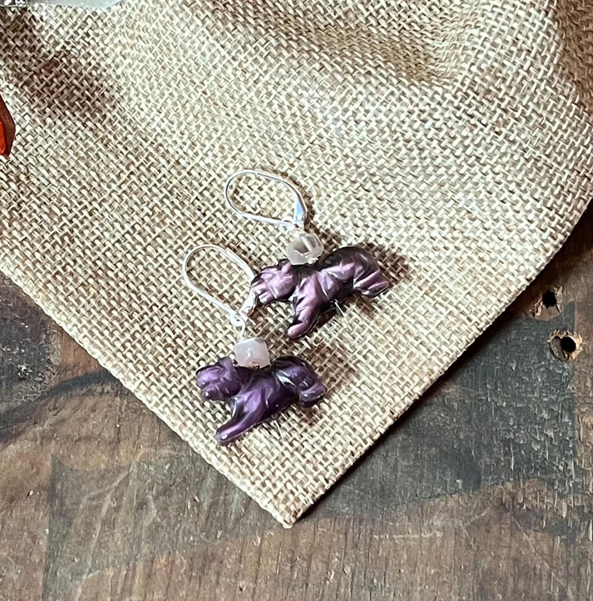 Panther Earrings: Bold purple earrings with big cat charms and Amethyst Cat's Eye stones, displayed on burlap over wood—perfect for adding Wild-Elegant Style to any look. Ideal gift for exotic animal and big cat lovers.