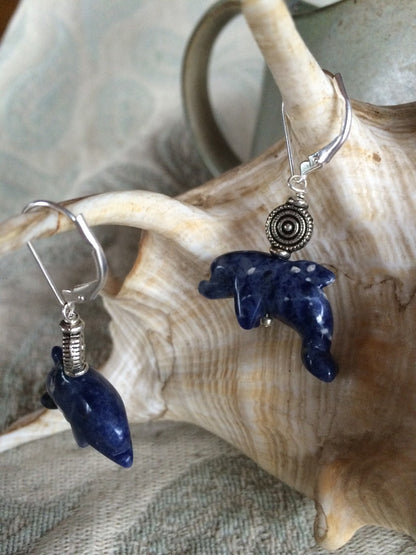 Close-up view of Sodalite dolphin earrings, highlighting the handcrafted blue dolphin design and sterling silver lever backs.
