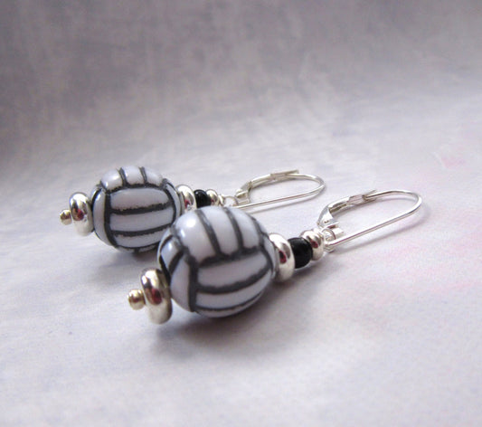 Handmade Volleyball Earrings featuring oval beads with black and white stripes, sterling silver lever backs, and sporty style—perfect for fans of unique sport jewelry. Displayed on a light background.