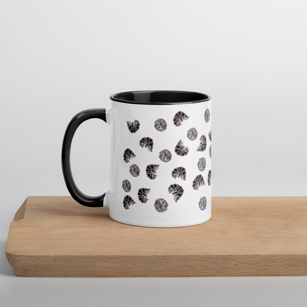 The Enlivenadorn by Gwynstone Roly Poly Pill Bug Isopod Mug with Color Inside features a charming black and white seashell illustration pattern on a white mug with a black handle and rim, displayed on a light wooden serving board against a plain white background—an ideal find for any arthropod hobbyist or pill bug isopod mug collector.